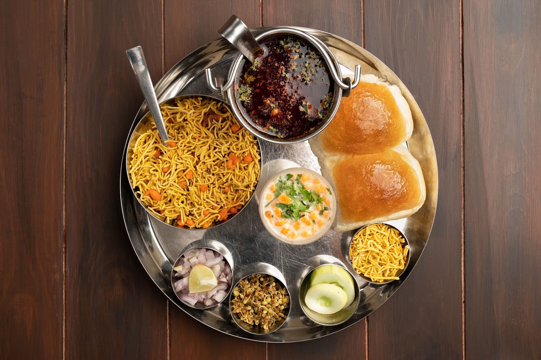 A Maharashtrian misal pav thali on a steel plate