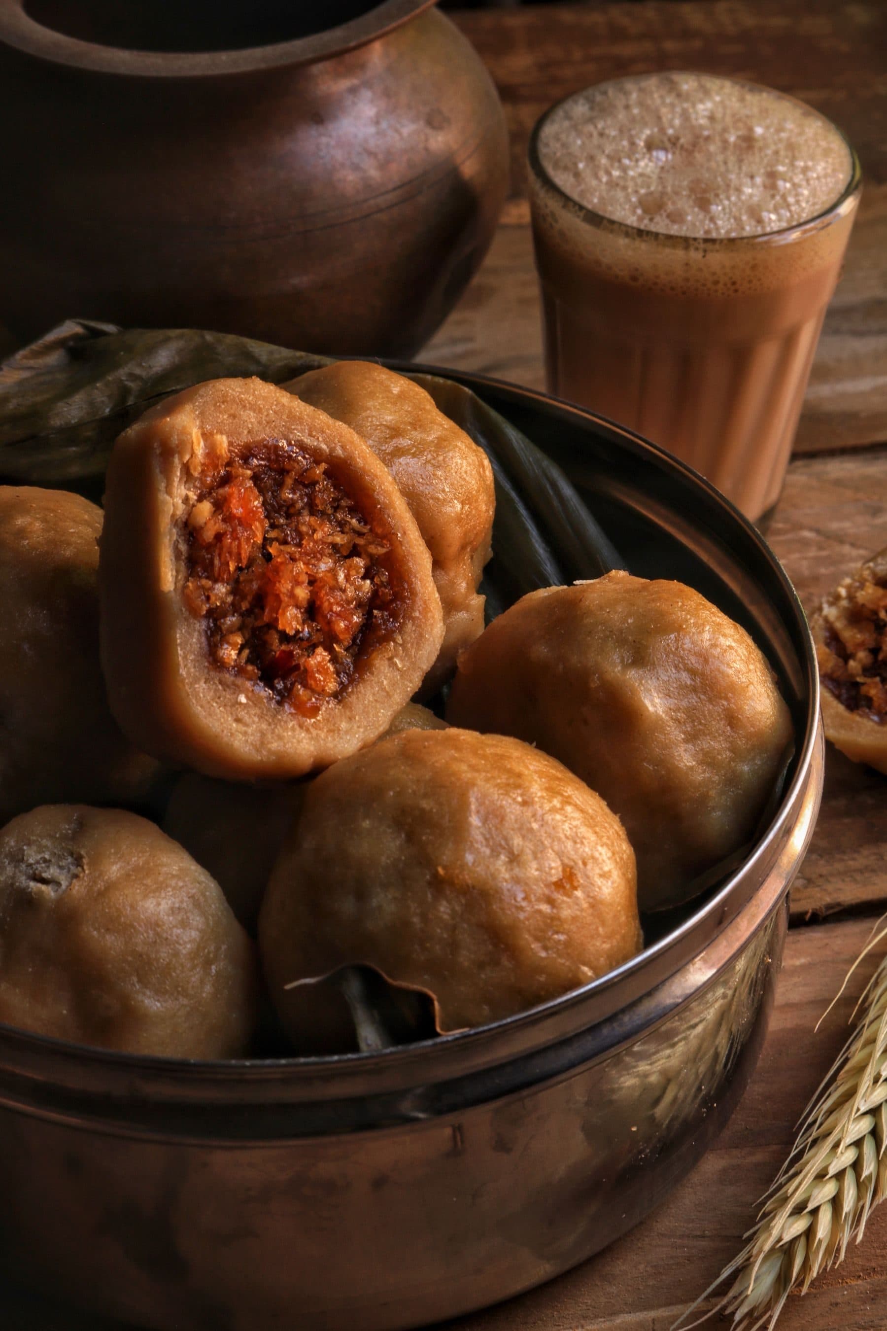 Modak in a brass bowl with a glass of chai